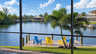 Blick durch die Lanai auf den privaten Bootssteg am Kanal mit Palmen und Sitzgelegenheiten - Traum-Urlaub-Florida