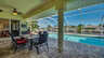 Outdoor-Essbereich mit Poolblick unter einer überdachten Terrasse. - Traum-Urlaub-Florida