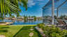 Blick auf den ruhigen Kanal mit üppigem Grün im Vordergrund und der Poolterrasse der Villa Donatella im rechten Bildbereich. - Traum-Urlaub-Florida