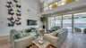 Modernes Wohnzimmer mit hohen Decken, Leder-Sofas und Schmetterlings-Wandkunst - Traum-Urlaub-Florida