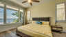 Helles Schlafzimmer mit gelber Bettwäsche, großem Fenster und Blick auf das Wasser. - Traum-Urlaub-Florida