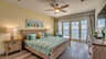 Gemütliches Schlafzimmer mit grünem Bett, Holzrahmen und direktem Zugang zum Balkon mit Wasserblick. - Traum-Urlaub-Florida