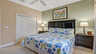Elegantes Schlafzimmer mit großem Kingsize-Bett, stilvollem dunklen Kopfteil und beruhigenden Grüntönen. - Traum-Urlaub-Florida