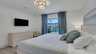 Modernes Schlafzimmer mit Queensize-Bett, Smart-TV und direktem Zugang zur Poolterrasse. - Traum-Urlaub-Florida