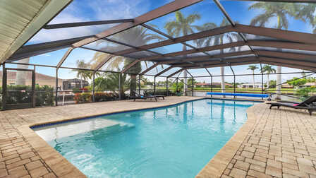 Überdachter Poolbereich mit großzügigem Swimmingpool, Liegen und Kanalblick in Cape Coral - Traum Urlaub Florida 