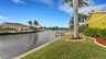 Blick auf den gepflegten Garten entlang des Kanals mit Bootsdock und tropischer Bepflanzung - direkt am Wasser gelegen. - Traum-Urlaub-Florida