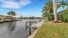 Privates Bootsdock mit Leiter am Kanal, umgeben von Palmen und gepflegtem Rasen - idealer Zugang zum Wasser. - Traum-Urlaub-Florida