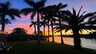 Farbenfroher Abendhimmel über dem Kanal - Palmen werfen lange Schatten, während der Sonnenuntergang die Szene in ein romantisches Licht taucht. - Traum-Urlaub-Florida