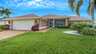Außenansicht der Villa Giorgio in Cape Coral mit gepflegtem Vorgarten, Palmen und Doppelgarage - einladend und charmant. - Traum-Urlaub-Florida