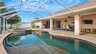 Terrasse mit Esstisch und Loungebereich unter Screen mit Blick auf Pool und Whirlpool - Traum-Urlaub-Florida