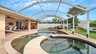 Poolbereich mit eingelassenem Whirlpool und überdachtem Essbereich, umgeben von einem winddurchlässigen Screen aus Aluminiumstreben und Fliegengitter-Gewebe. - Traum-Urlaub-Florida