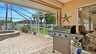 Moderner Gasgrill im geschützten Terrassenbereich mit Blick auf den Garten und den Pool, alles umgeben von einer luftdurchlässigen Screen-Konstruktion. - Traum-Urlaub-Florida