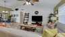 Helles Wohnzimmer mit gemütlichen Sofas, Fernseher, Deckenventilator und dekorativem Bücherregal in einem Ferienhaus in Cape Coral. - Traum-Urlaub-Florida