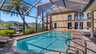 Überdachter Poolbereich der Villa Kasar mit Palmenblick, Sonnenliegen und Zugang zum Kanal im Hintergrund. - Traum-Urlaub-Florida