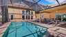 Überdachte Terrasse mit Esstisch und Liegestühlen am sonnigen Poolbereich mit Screen und hohen Fenstern im Hintergrund - Traum-Urlaub-Florida