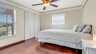 Helles Schlafzimmer mit Holzfußboden, Deckenventilator und großem Fenster für natürliches Licht. - Traum-Urlaub-Florida