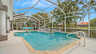 Blick auf den großzügigen Pool und Spa-Bereich mit Sitzgruppe und Palmen am Wasser - Traum-Urlaub-Florida