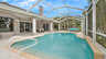 Poolbereich mit überdachter Terrasse, Essbereich und Lounge-Ecke im Hintergrund. - Traum-Urlaub-Florida