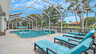 Reihe türkisfarbener Sonnenliegen am Pool mit Blick auf Palmen und Wasser. - Traum-Urlaub-Florida