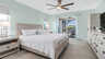 Hauptschlafzimmer mit Kingsize-Bett, Nachttischen, Deckenventilator und Zugang zur überdachten Terrasse mit Wasserblick. - Traum-Urlaub-Florida