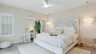 Gästesuite: Elegantes Schlafzimmer mit weißem Kingsize-Bett, dekorativem Kopfteil und sanfter Beleuchtung. - Traum-Urlaub-Florida
