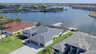 Blick auf die Rückseite des Hauses mit überdachtem Bootslift und großzügigem Screen-Bereich am Wasser. - Traum-Urlaub-Florida