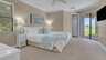 Helles in dezenten Farben eingerichtetes Schlafzimmer mit Kingsize-Bett, TV und direktem Zugang zur Terrasse - Traum-Urlaub-Florida