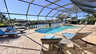 Weitläufiger Poolbereich mit Sonnenliegen, Whirlpool und Screened Patio mit freiem Blick auf den Kanal. - Traum-Urlaub-Florida