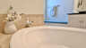 Detail der Badewanne mit hübscher Deko und gemütlicher Sitzbank im hellen Bad. - Traum-Urlaub-Florida