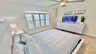 Helles Schlafzimmer mit Queen-Size-Bett, TV, Deckenventilator und großen Fensterläden. - Traum-Urlaub-Florida