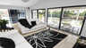 Heller Wohnbereich mit Sofas, großer Fensterfront und Blick auf Terrasse und Kanal - Traum-Urlaub-Florida