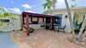Überdachte Outdoor-Küche mit Grill, Sitzbereich und tropischem Ambiente im Garten - Traum-Urlaub-Florida