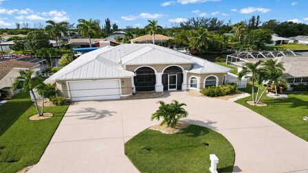 Ferienhaus Villa Almare in Cape Coral mit weißem Metalldach und kreisförmiger Einfahrt - Traum Urlaub Florida 