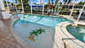 Geschwungener Pool mit Palmenmosaik, erhöhtem Spa und überdachtem Kanalsteg im Hintergrund - Traum-Urlaub-Florida
