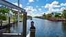 Kanal neben Metallrahmen eines Bootslifts, Pfosten mit Seilen und rotem Uferdeck - Traum-Urlaub-Florida