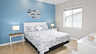 Schlafzimmer mit Queensize-Bett, blauer Akzentwand, Fisch-Wanddeko und zwei Lampen - Traum-Urlaub-Florida