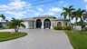 Vorderansicht eines eingeschossigen Hauses mit bogenförmigem Screen-Eingang, Garage und Rundauffahrt - Traum-Urlaub-Florida