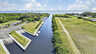 Gerader Kanal zum offenen Meer mit Marina-Steg, Bootsrampe und ferner Hochhaus-Skyline - Traum-Urlaub-Florida