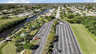 Uferpark mit palmengesäumtem Parkplatz, grünen Pavillons und Häusern entlang des Kanals - Traum-Urlaub-Florida