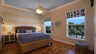 Schlafzimmer mit Korbbett, blau gestreifter Bettwäsche, Deckenventilator und zwei Fenstern zum Kanal - Traum-Urlaub-Florida