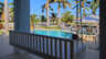 Überdachte Terrasse mit weißer Schaukelbank und Blick auf Freiformpool, Spa und Kanal - Traum-Urlaub-Florida
