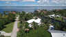 Luftaufnahme von Kanalhäusern mit weißen Dächern, Palmen und breitem Fluss - Traum-Urlaub-Florida