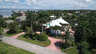Luftaufnahme von weißem Haus mit rosa Rundauffahrt, Palmen und Fluss im Hintergrund - Traum-Urlaub-Florida