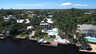 Luftaufnahme von Kanaluferhäusern mit Bootsdocks, geschwungenem Pool, Pavillon und hohen Palmen - Traum-Urlaub-Florida