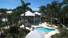 Luftaufnahme eines zweigeschossigen Hauses mit geschwungenem Pool, Spa und hohen Palmen - Traum-Urlaub-Florida