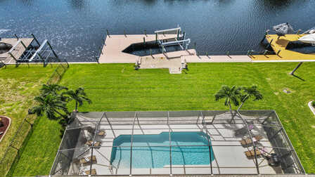 Blick von oben auf die Poolterrasse, den Bootslift mit Dock und den Kanal  - Traum Urlaub Florida 
