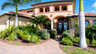 Mediterrane Villa mit Palmen, gepflegtem Vorgarten, Tor, Rundbögen und gepflasterter Einfahrt - Traum-Urlaub-Florida
